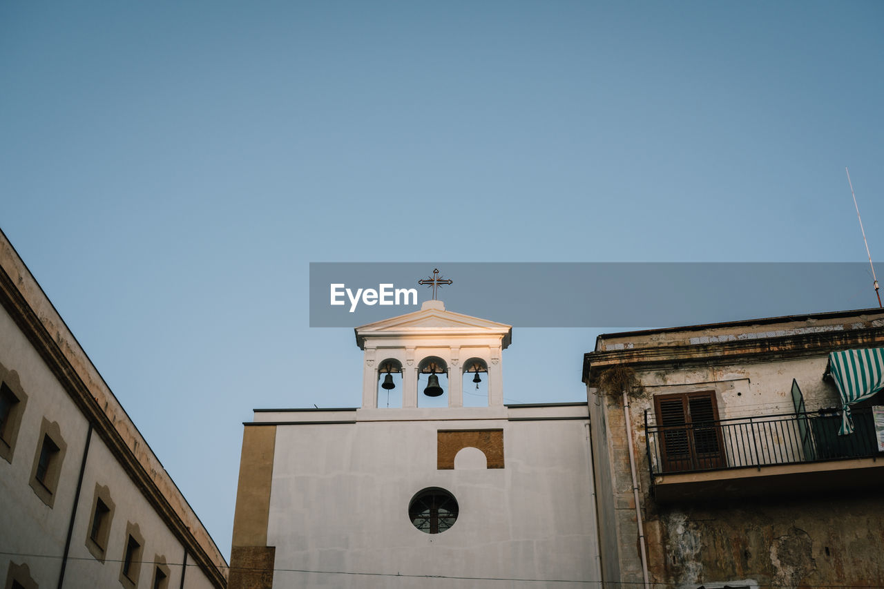 architecture, building exterior, built structure, sky, building, place of worship, religion, clear sky, belief, nature, no people, travel destinations, tower, history, spirituality, the past, city, low angle view, blue, clock, day, landmark, copy space, sunny, outdoors, travel, facade, time, bell tower, catholicism