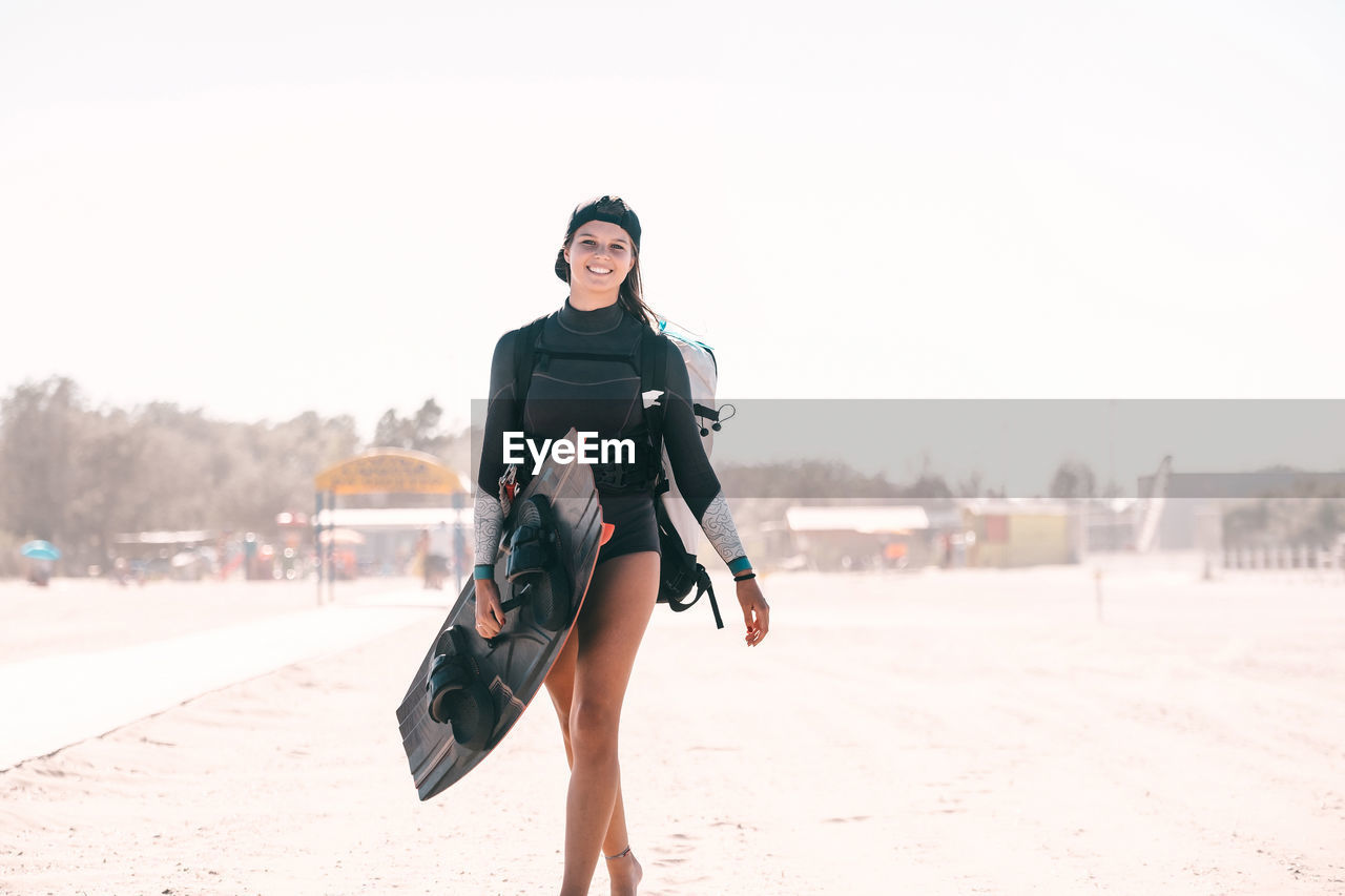 portrait of woman standing at beach against sky