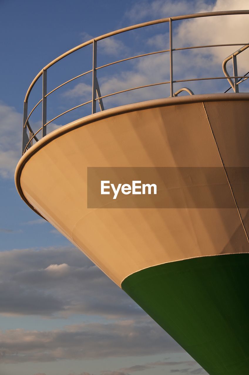 Low angle view of ship against cloudy sky during sunset