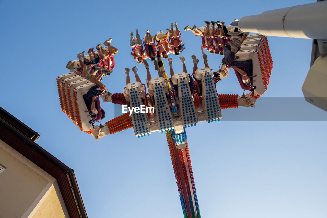 Spinning carnival ride with people enjoying at fun fair, an exciting amusement park attraction