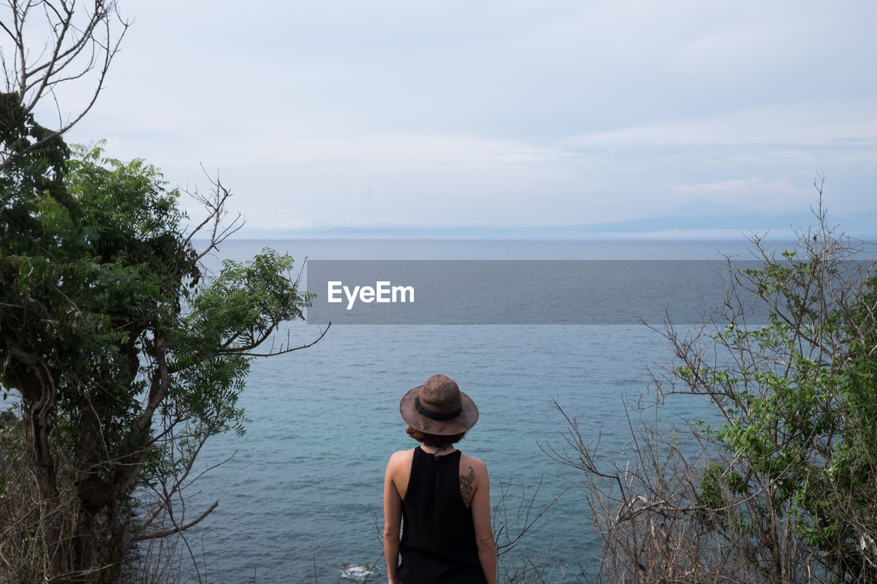 Rear view of lonely person contemplating the sea