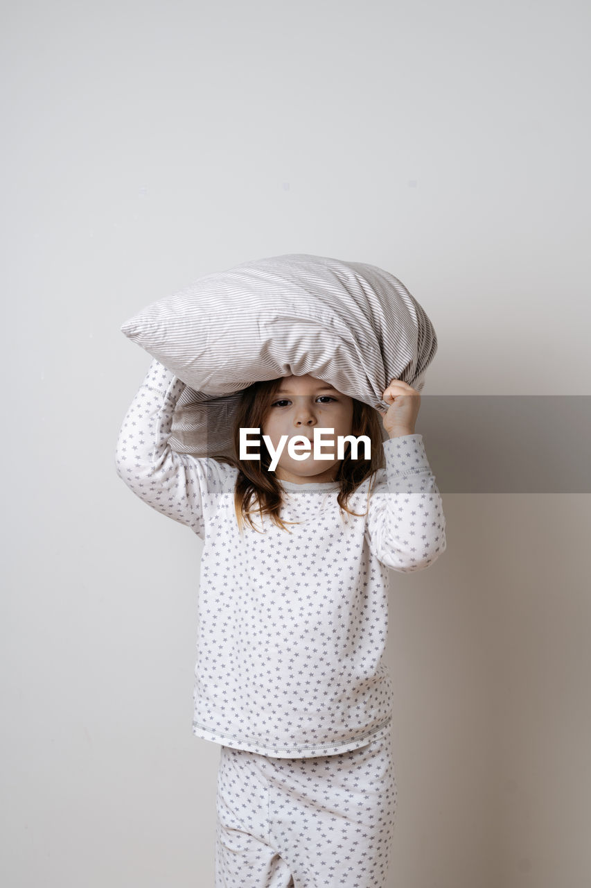 portrait of cute girl wearing hat against white background