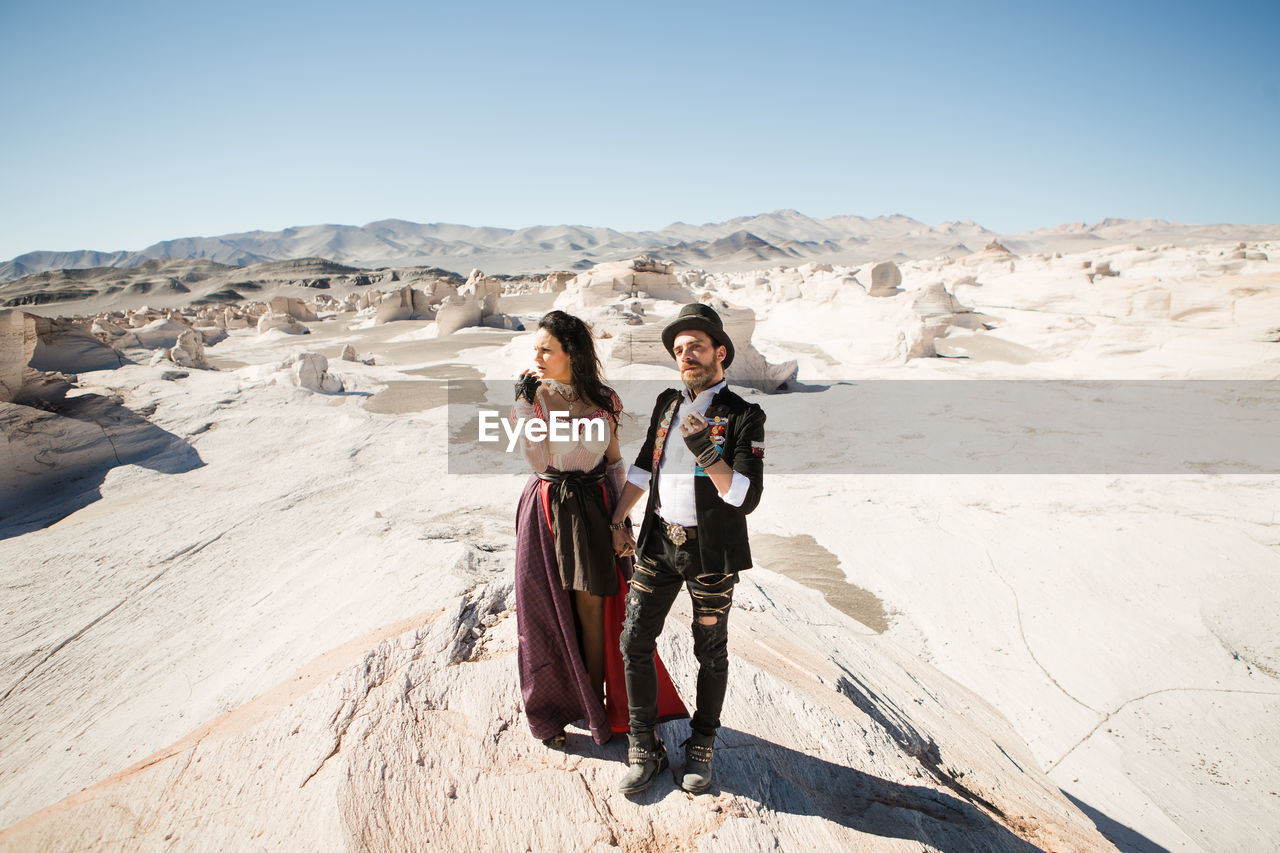 PORTRAIT OF WOMEN STANDING ON LAND AGAINST SKY