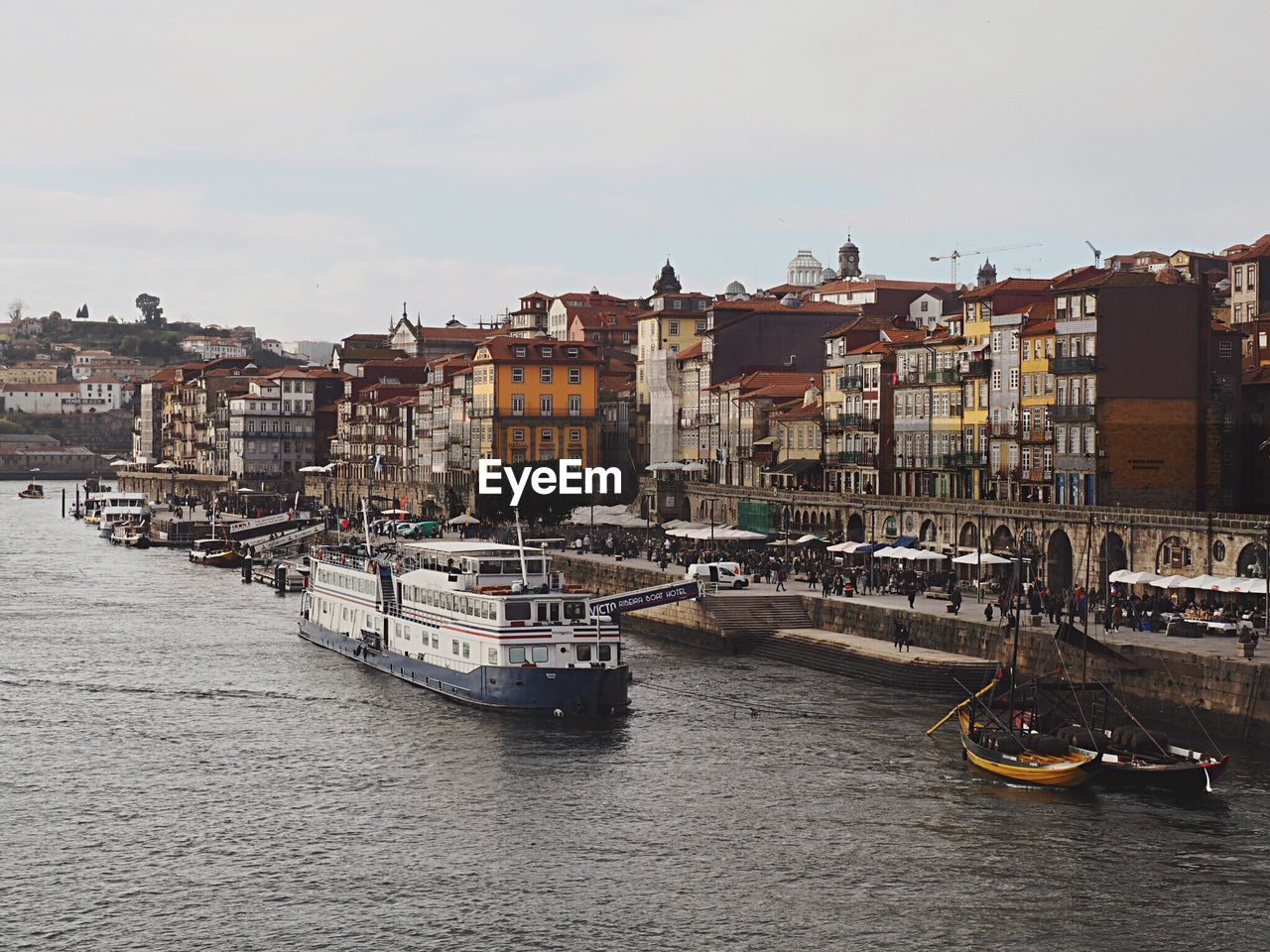 BOATS IN RIVER AGAINST BUILDINGS