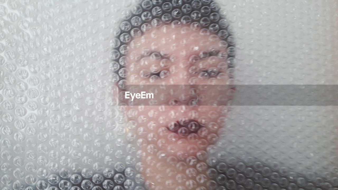 Close-up of woman seen through bubble bag