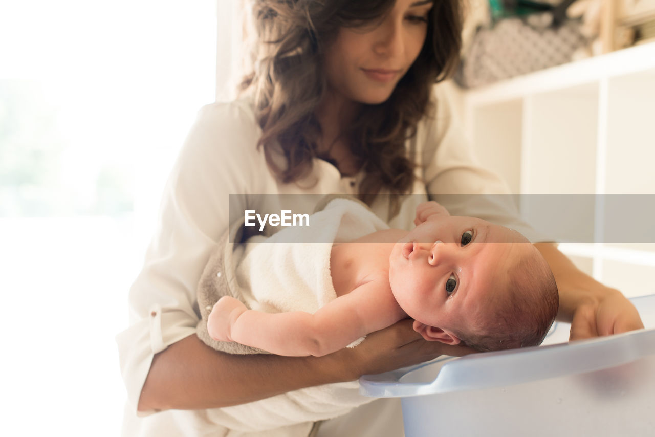 Mother bathing son in bathtub at bathroom