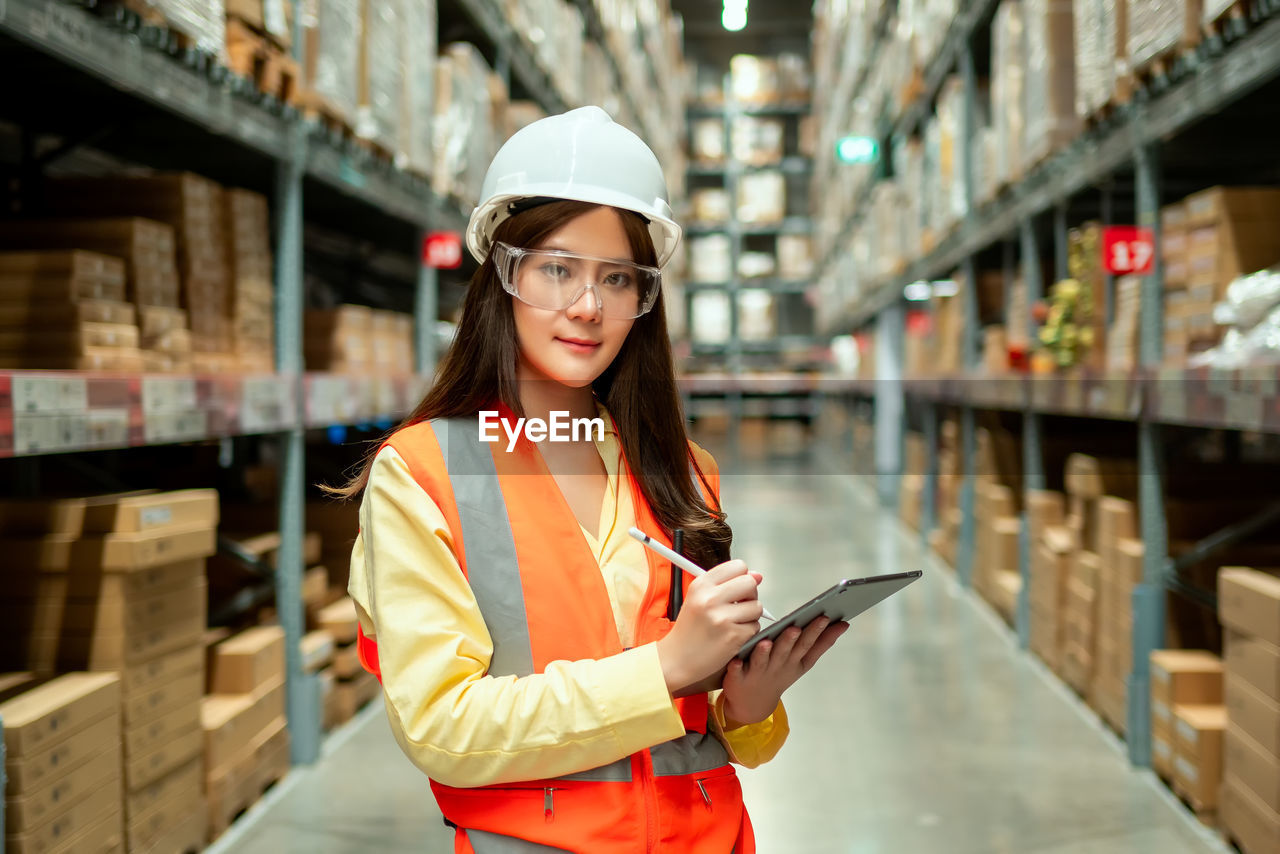 Female warehouse worker inspecting a warehouse in a factory. 