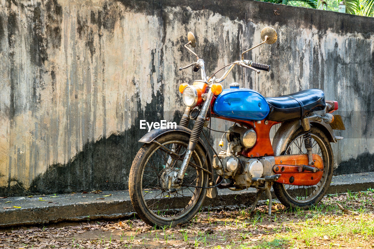 BICYCLE PARKED BY WALL