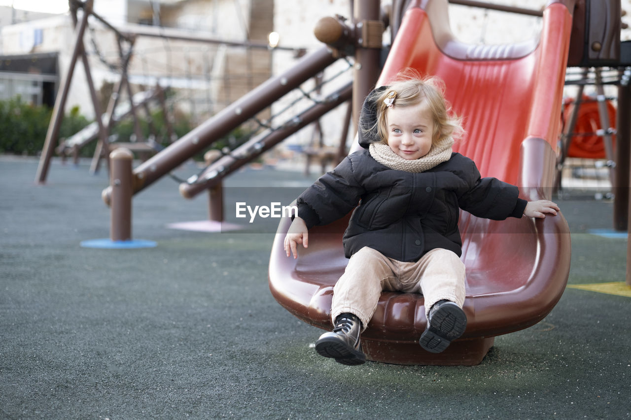 Baby girl sliding,having warm clothing child,kid,toddler, infant of 1-2 year fun in playground 