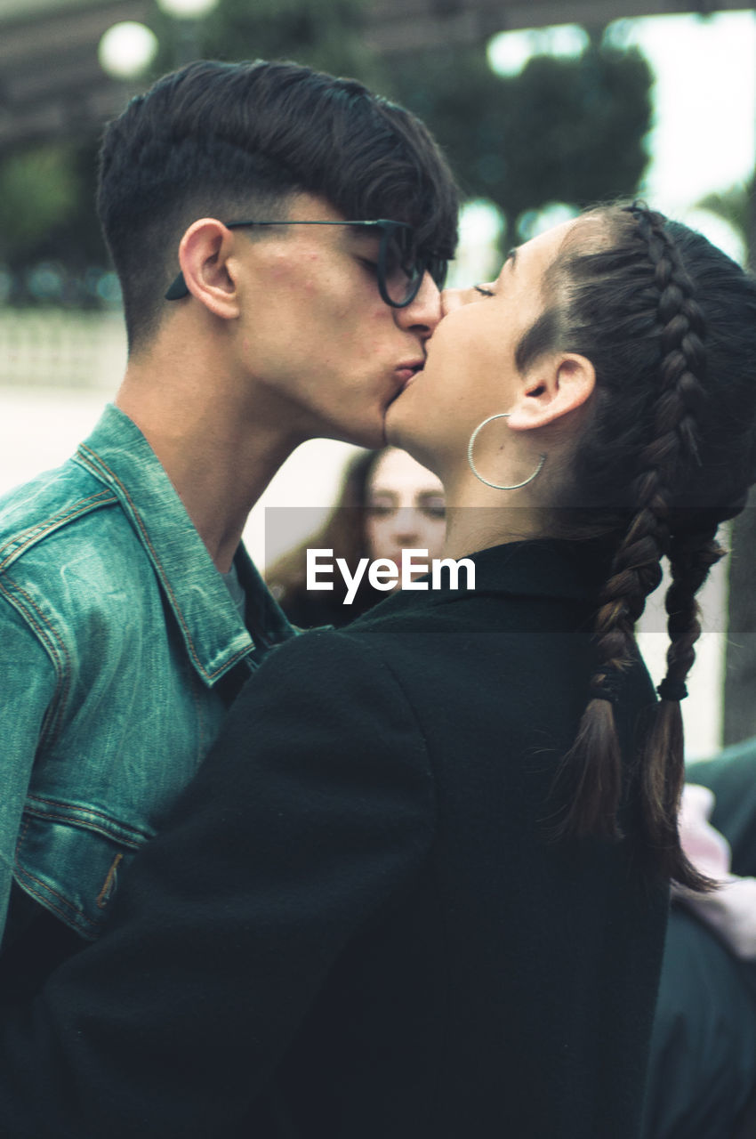 Close-up of couple kissing while standing outdoors