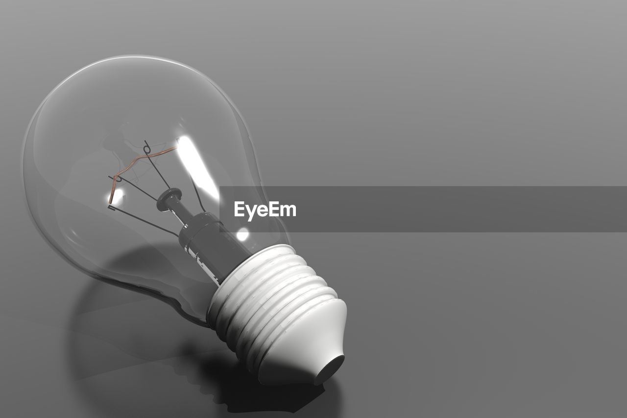 Close-up of light bulb over gray background