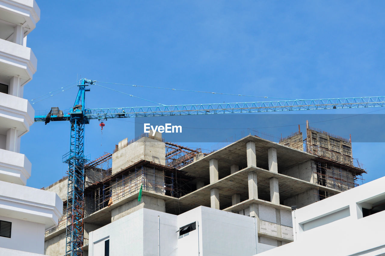 LOW ANGLE VIEW OF BUILDINGS AGAINST BLUE SKY