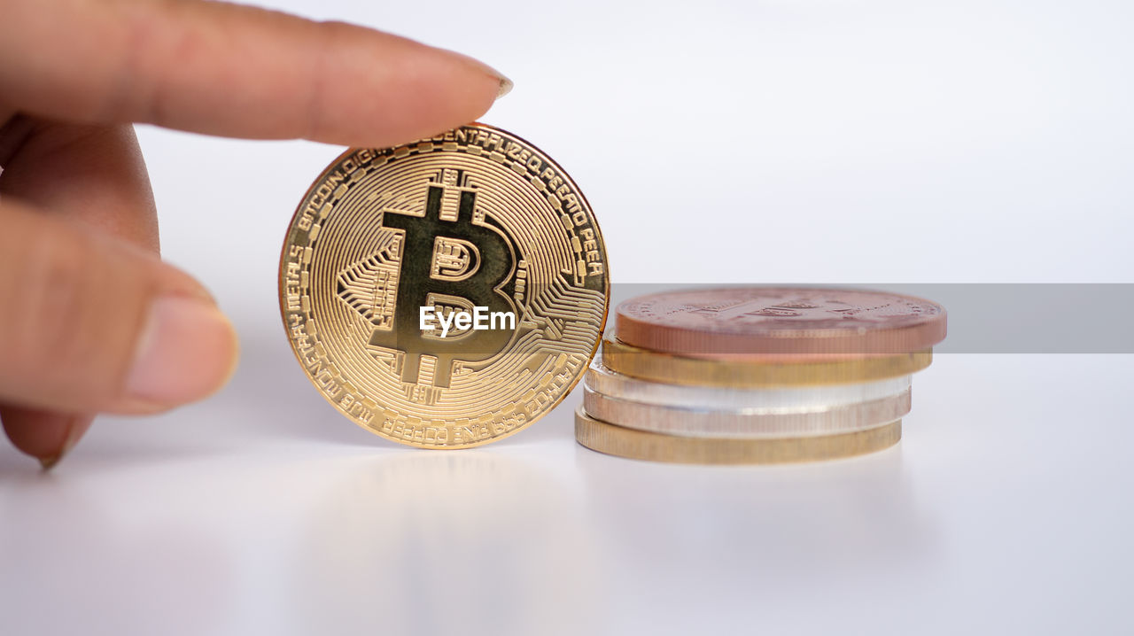 CLOSE-UP OF HAND HOLDING COIN