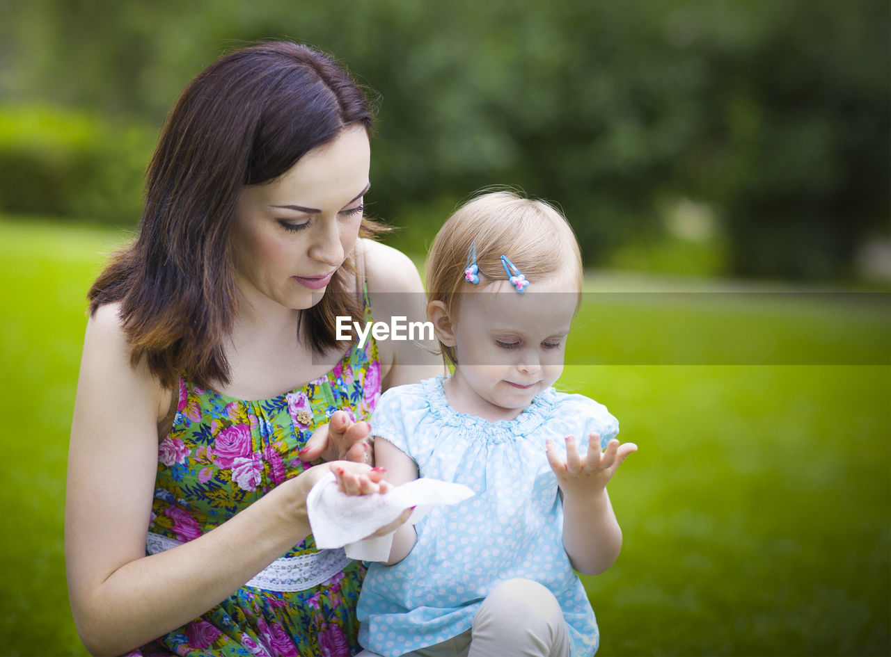 Mother and daughter sitting at park