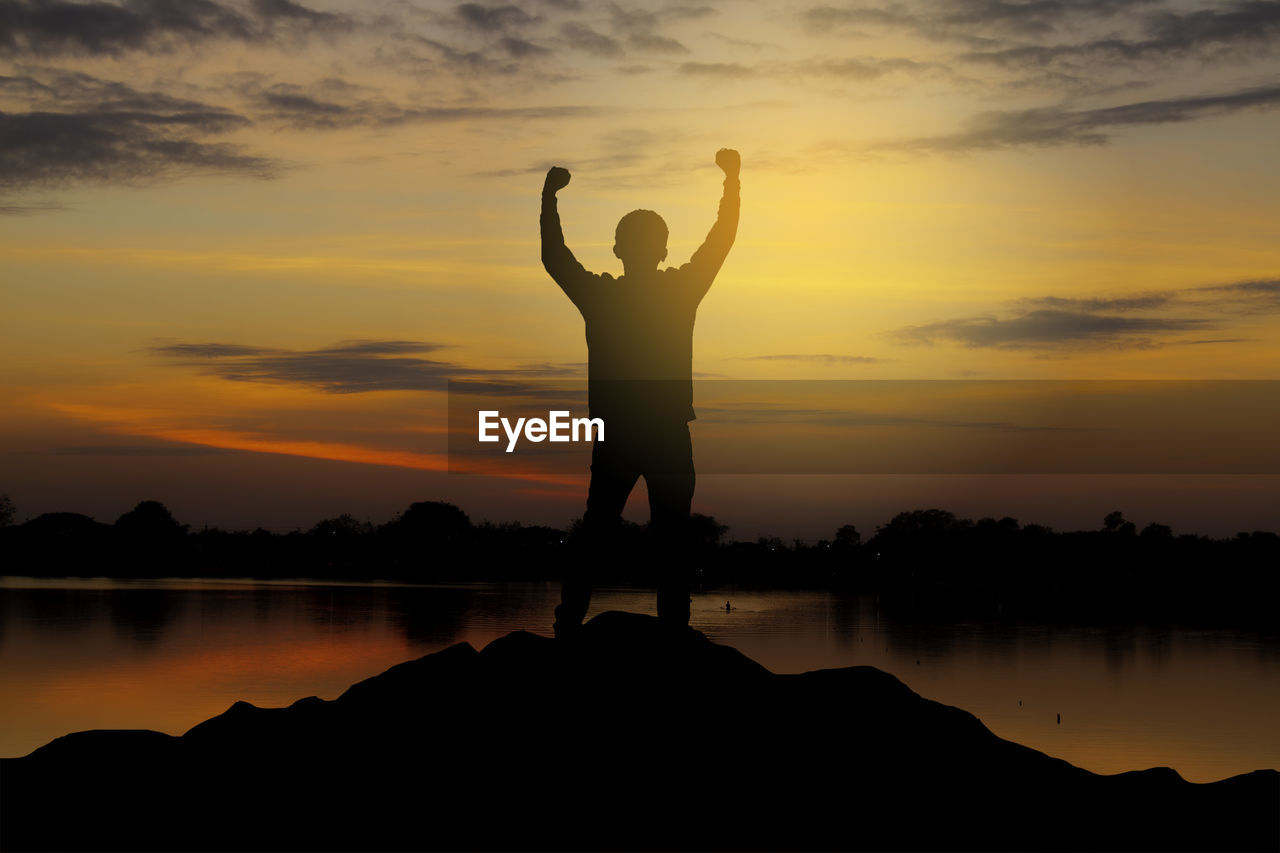 	
silhouette of a happy man raised hands up as a successful, victory and achieve a business goal.