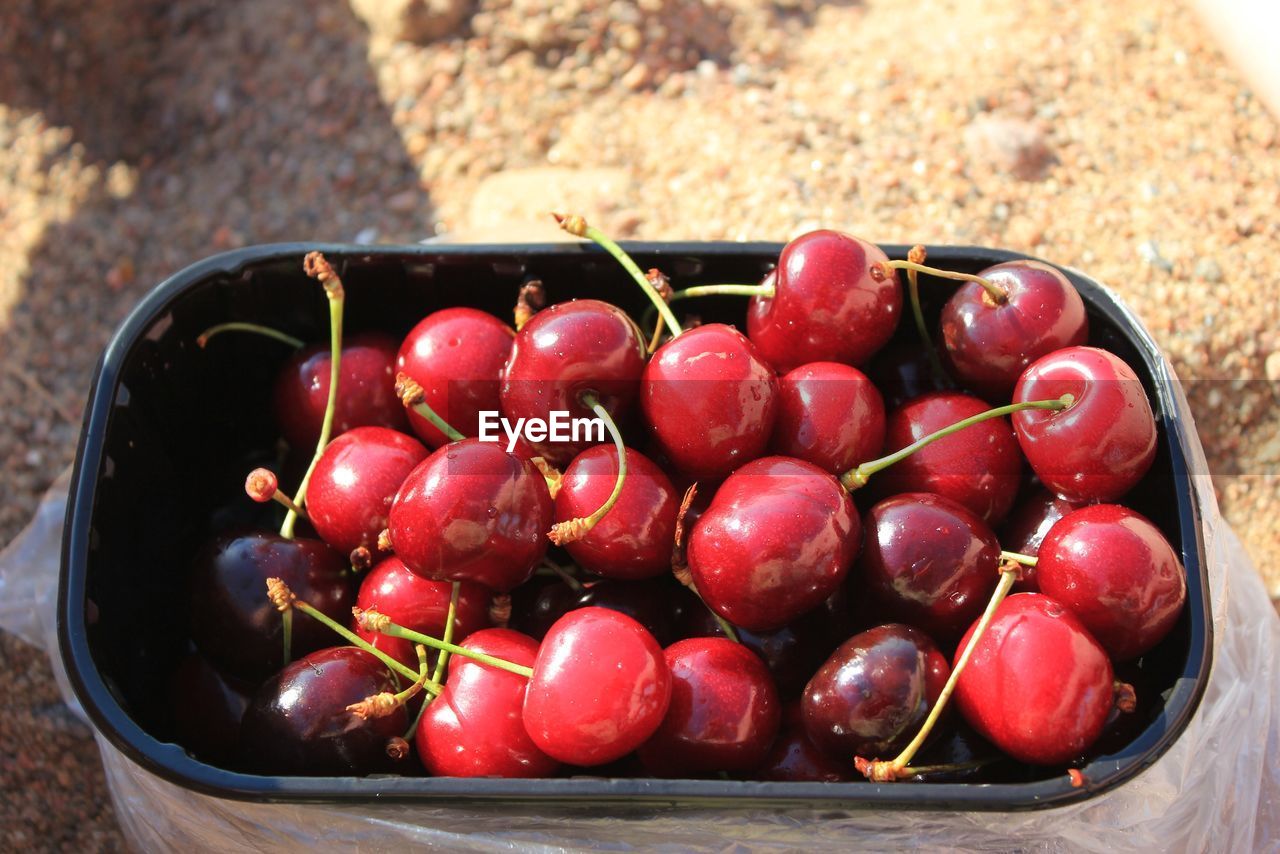HIGH ANGLE VIEW OF CHERRIES ON RED