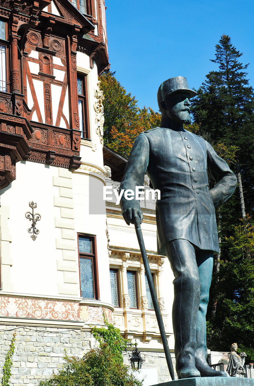 LOW ANGLE VIEW OF STATUES AGAINST BUILDING