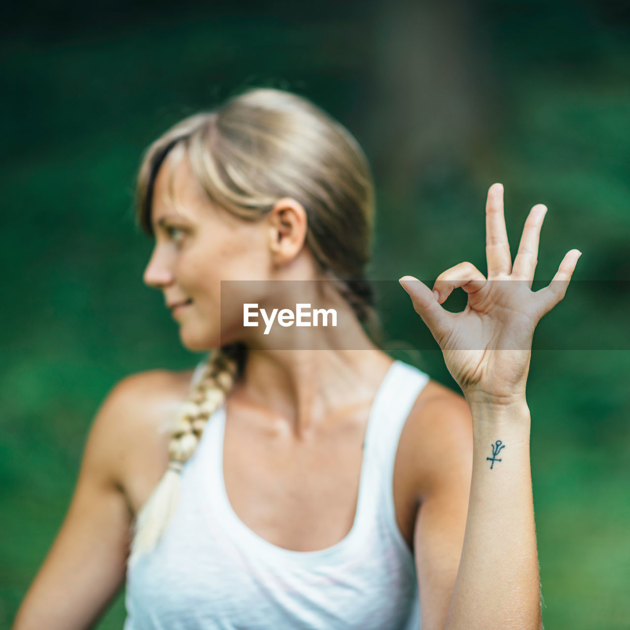 Young woman looking away while gesturing in park