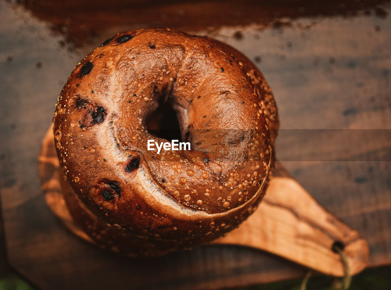 Above stack of blueberry bagels on small olive wood cutting board