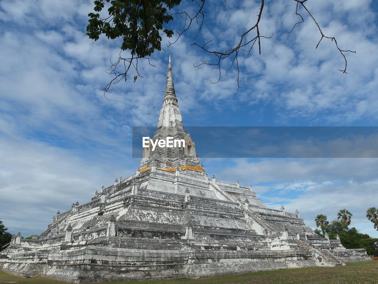 Wat phu khao thong against cloudy sky