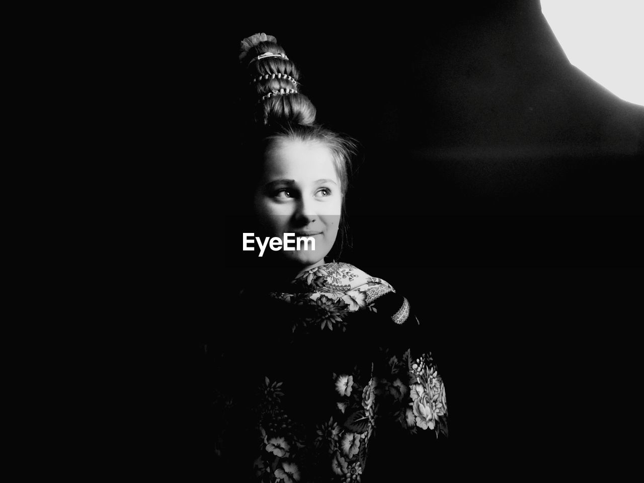 Close-up of girl looking away against black background