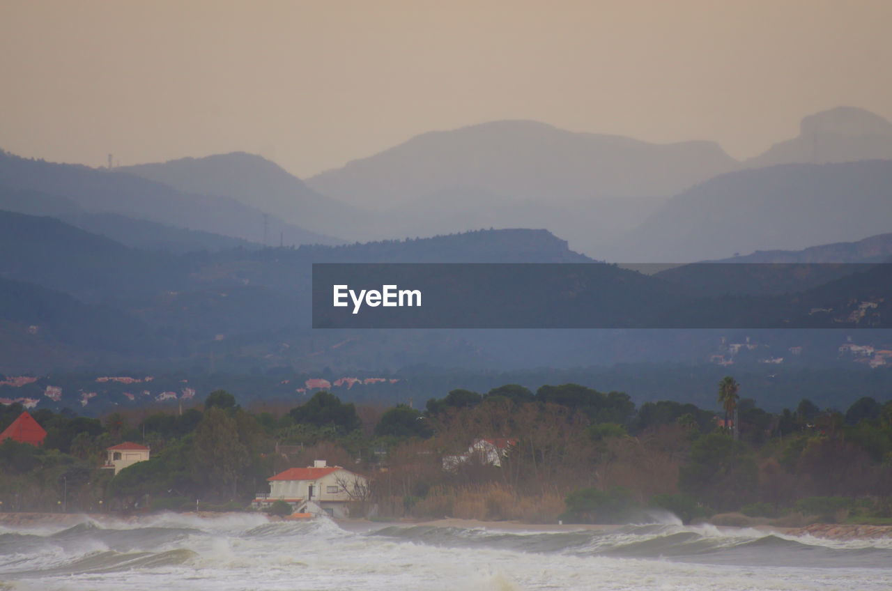 SCENIC VIEW OF BEACH AGAINST MOUNTAINS