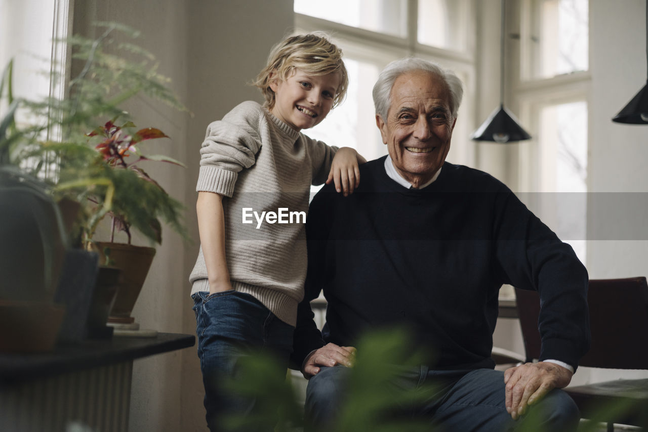 Portrait of happy grandfather and grandson at home