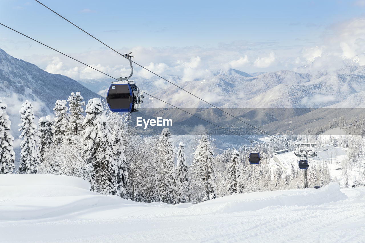 snow, winter, cold temperature, mountain, cable car, scenics - nature, mountain range, overhead cable car, beauty in nature, piste, ski lift, landscape, nature, environment, transportation, travel, cable, ski equipment, sky, tranquil scene, ski, land, snowcapped mountain, mode of transportation, tree, white, travel destinations, skiing, tranquility, non-urban scene, winter sports, day, plant, holiday, forest, cloud, vacation, frozen, journey, idyllic, outdoors, architecture, blue, trip, tourism, nordic skiing, ski mountaineering, ski resort, valley, sports equipment, resort