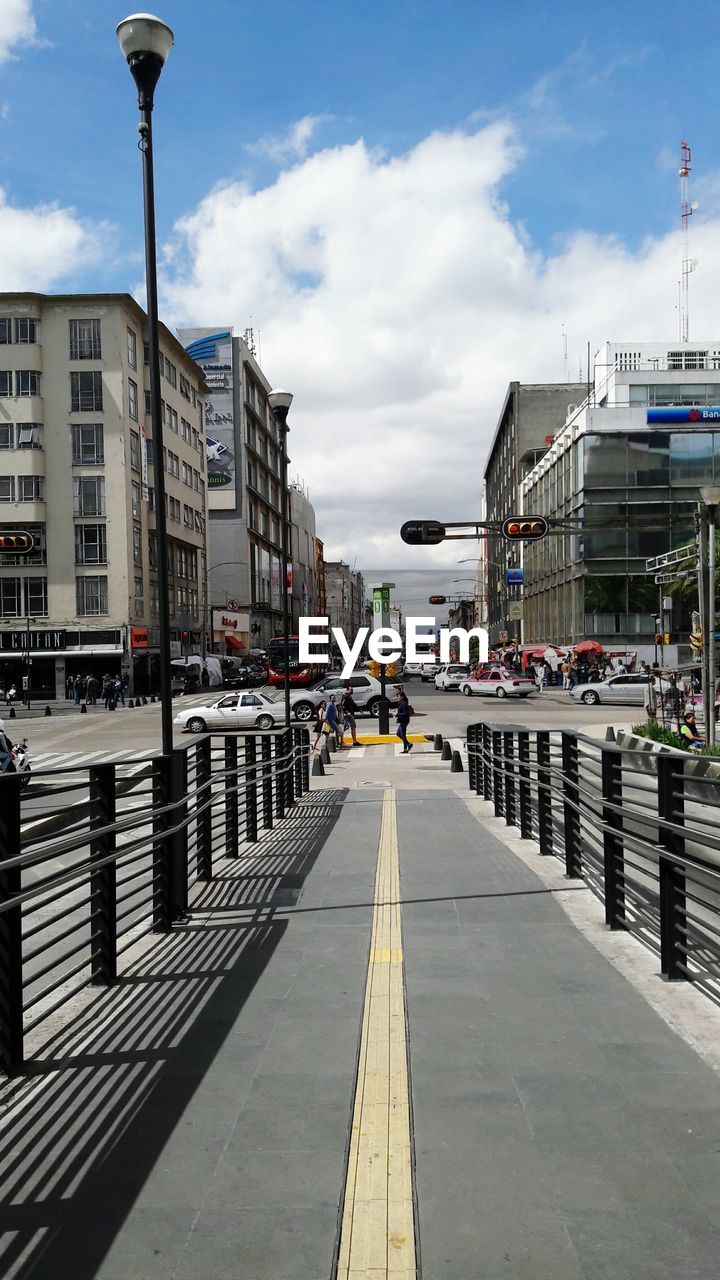 VIEW OF CITY STREET AGAINST CLOUDY SKY