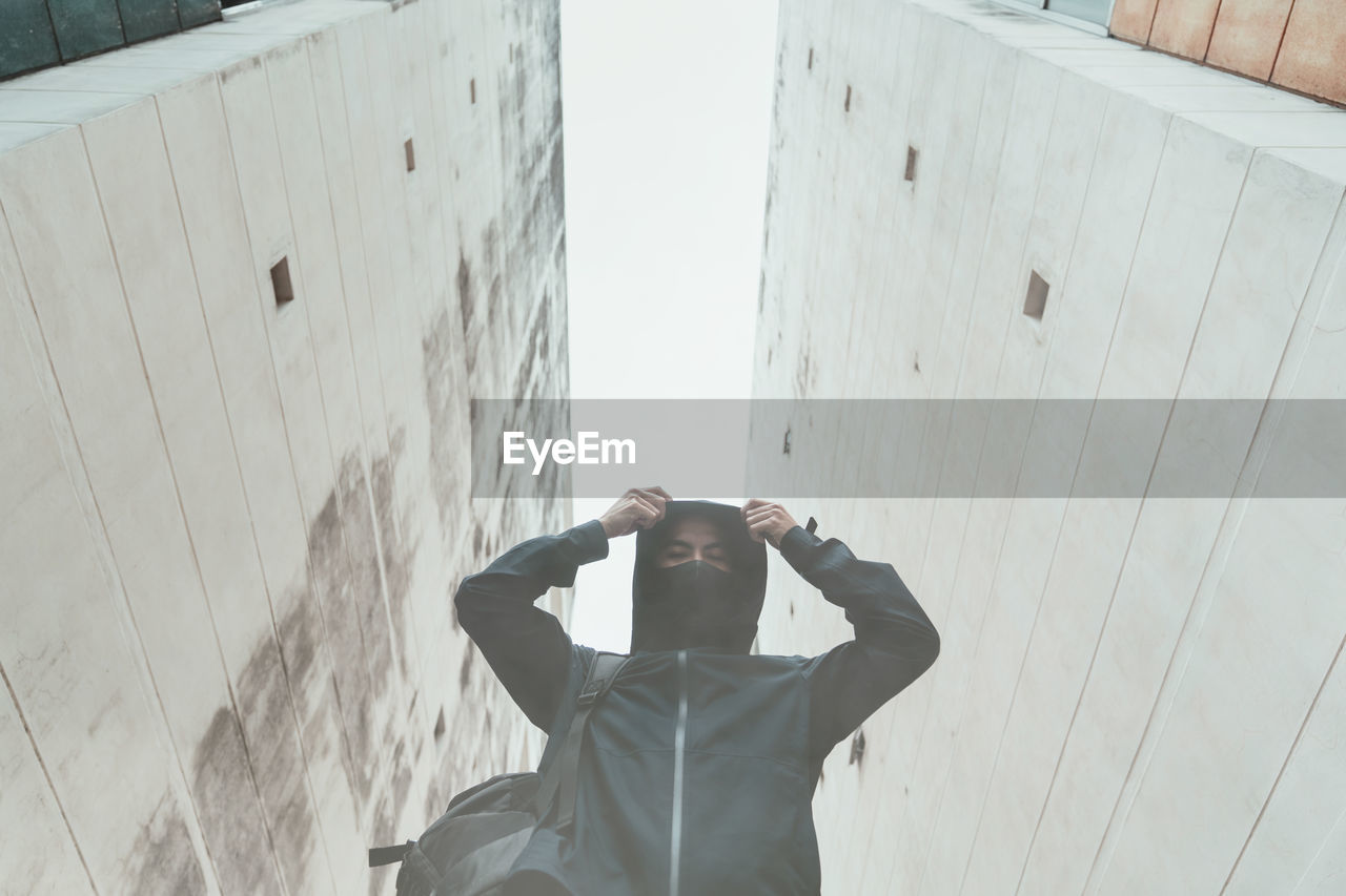 Low angle view of man standing against buildings