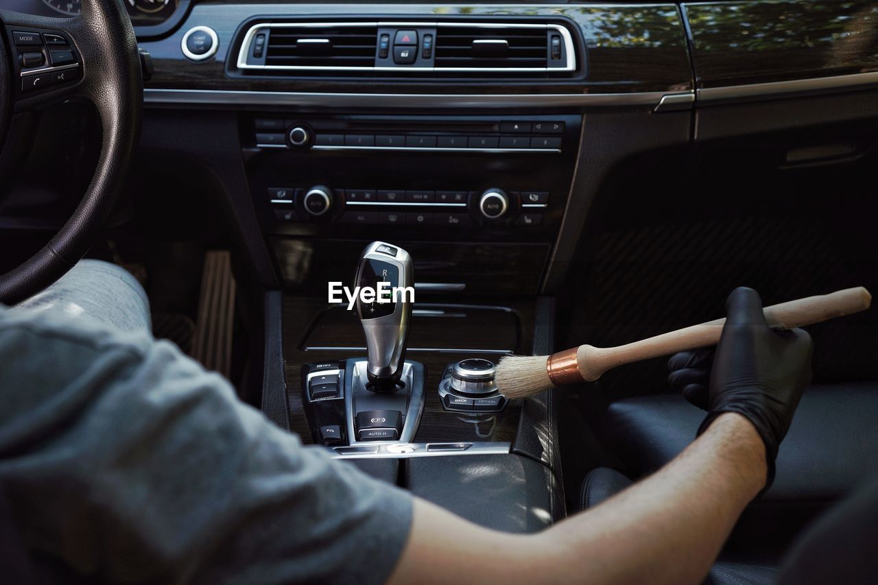 Cropped image of man cleaning button in car