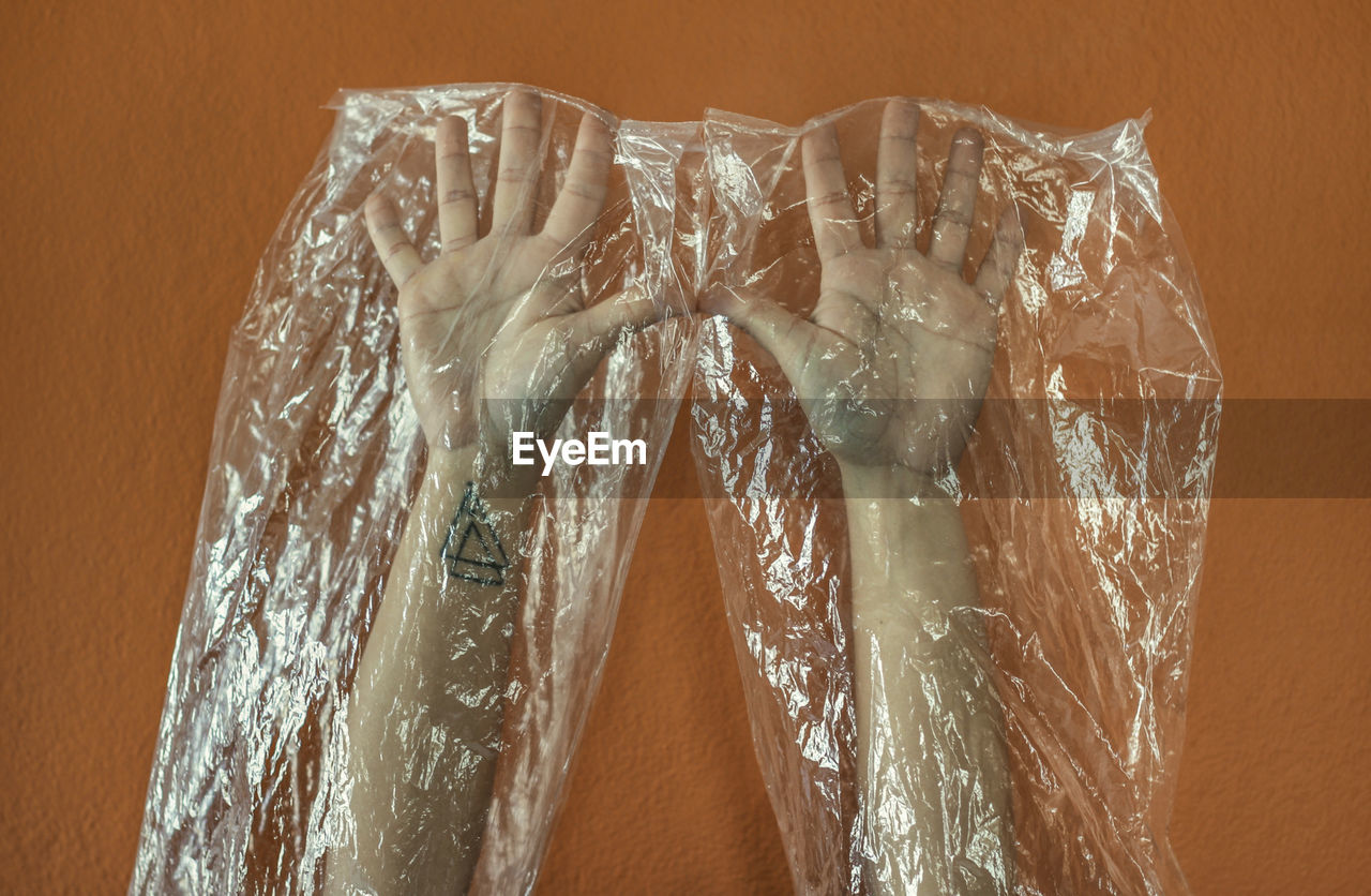 Close-up of hands covered with plastic bag 
