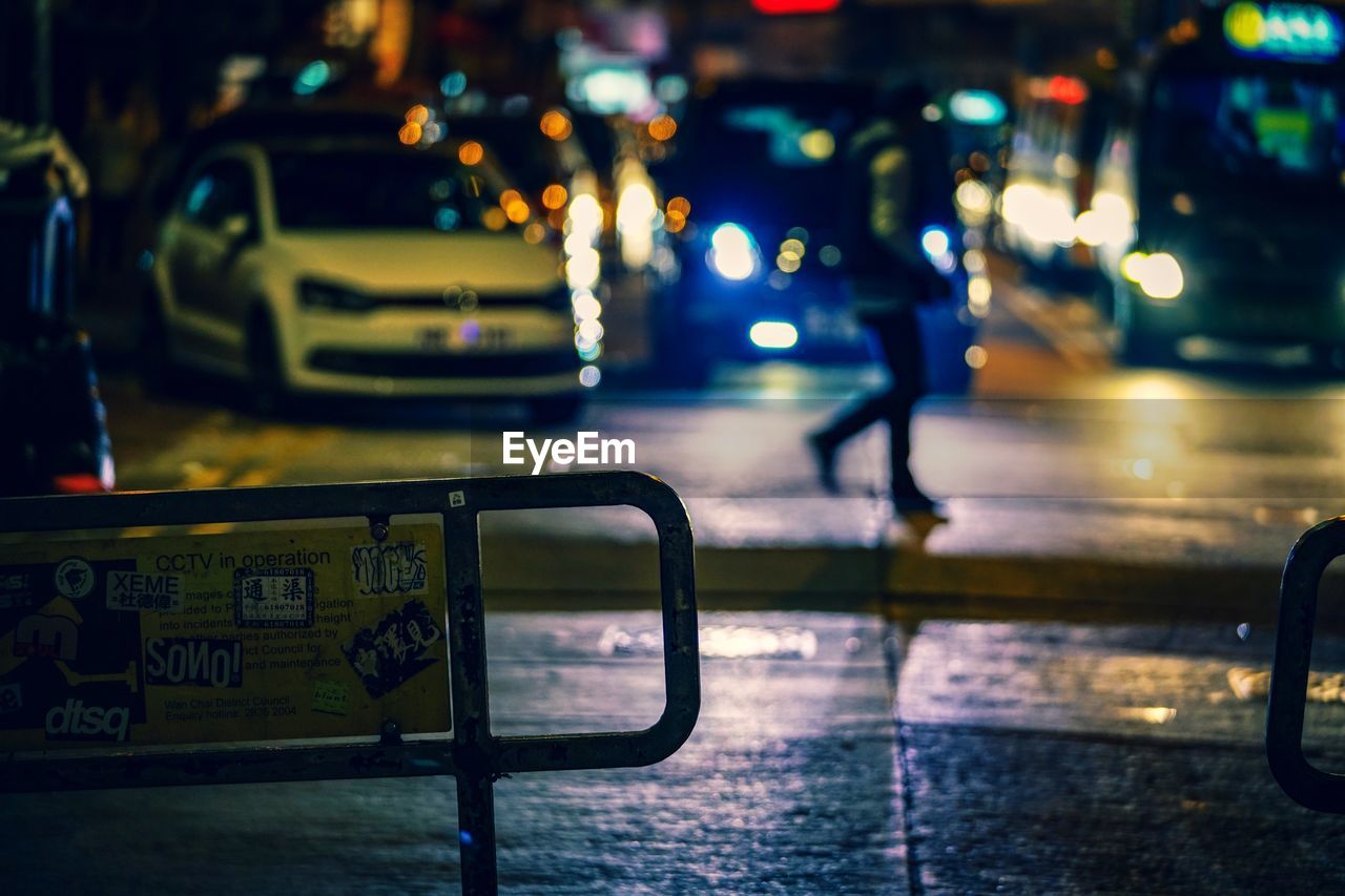 CLOSE-UP OF CAR ON ILLUMINATED STREET AT NIGHT