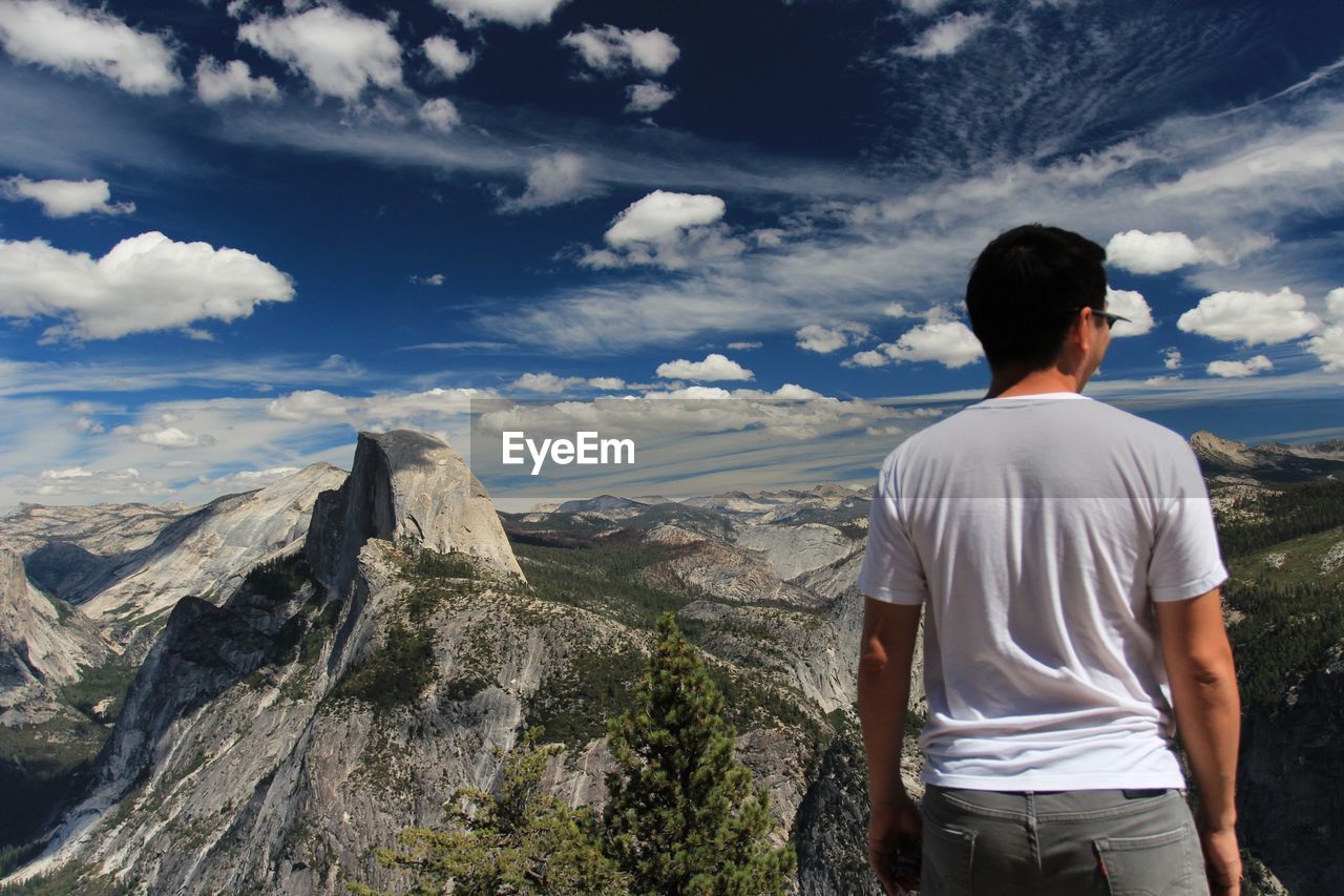 Rear view of man looking at mountain view against sky