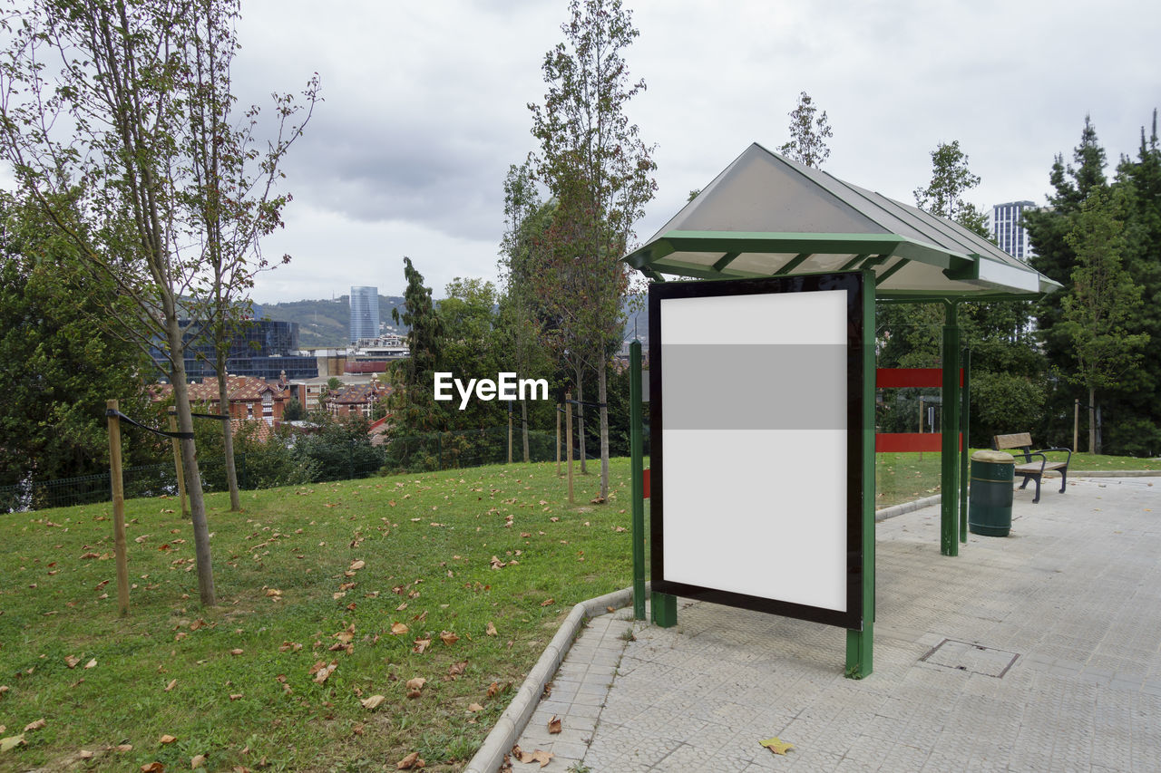 GAZEBO ON FOOTPATH BY BUILDING AGAINST SKY