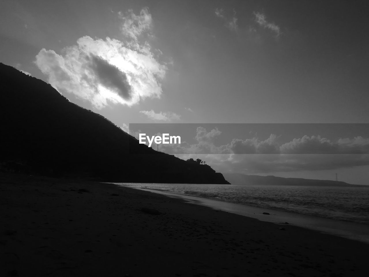 SCENIC VIEW OF BEACH BY SILHOUETTE MOUNTAIN AGAINST SKY