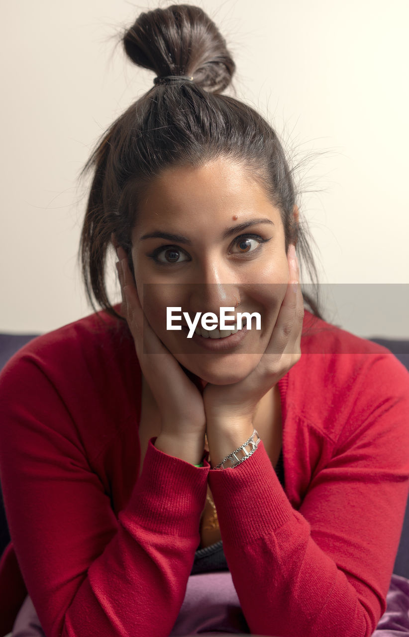 Portrait of beautiful young woman sitting at home