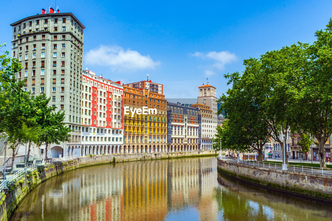 bridge over river in city against clear sky