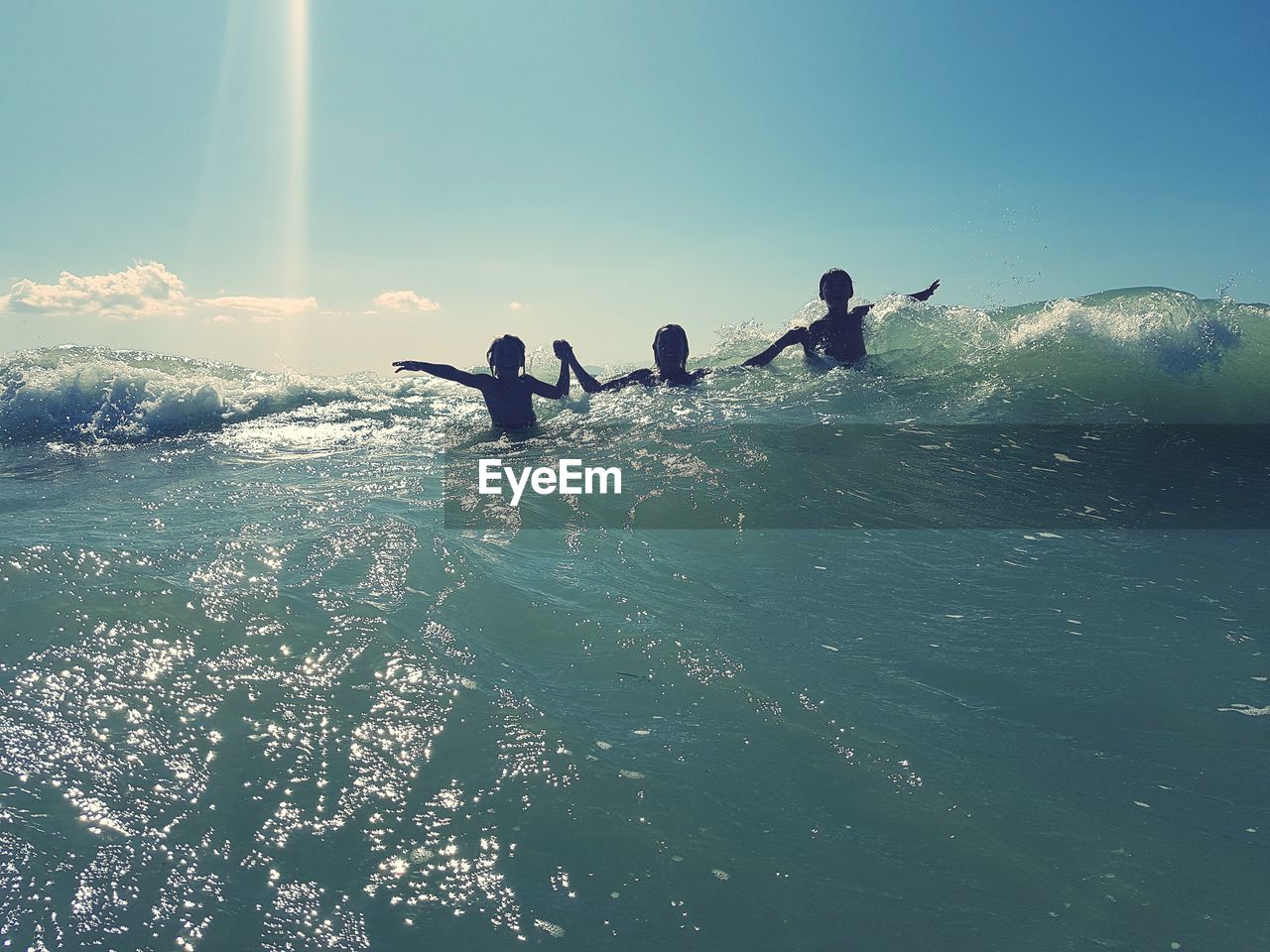 People enjoying in sea against sky