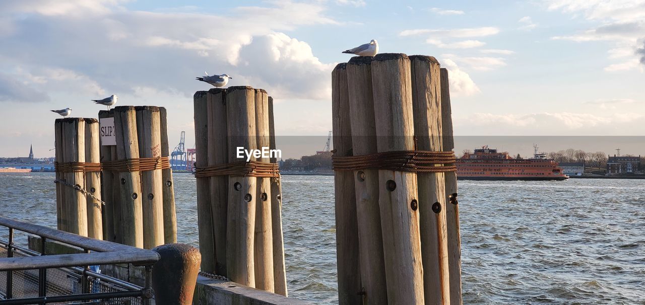 PANORAMIC VIEW OF WOODEN POST BY SEA AGAINST SKY