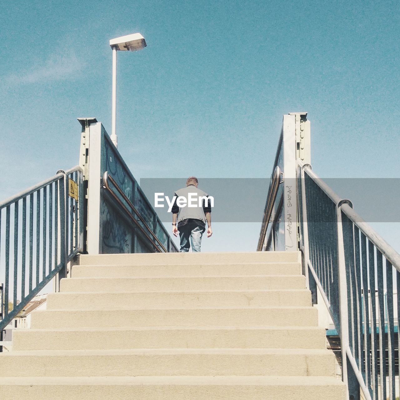 Rear view of man walking up stairs