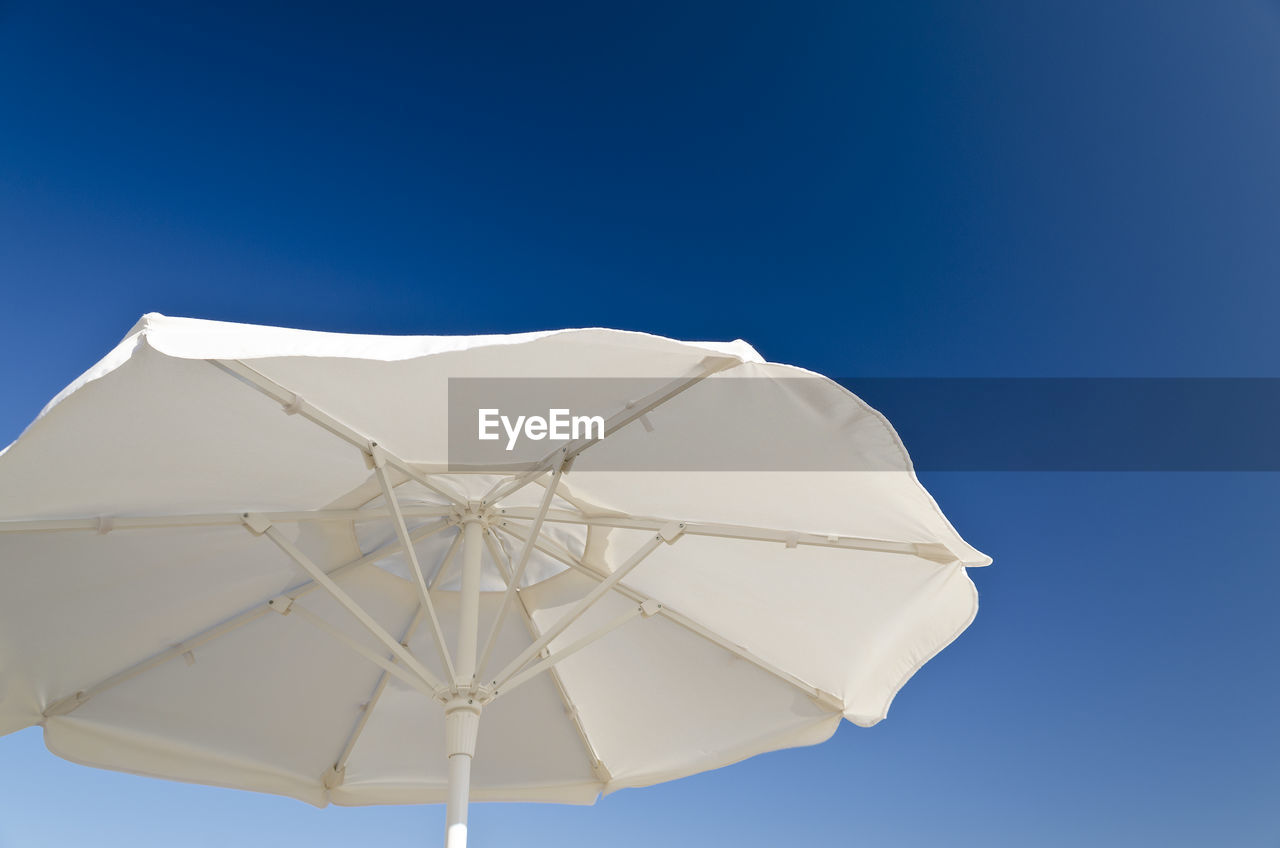 LOW ANGLE VIEW OF UMBRELLA AGAINST BLUE SKY