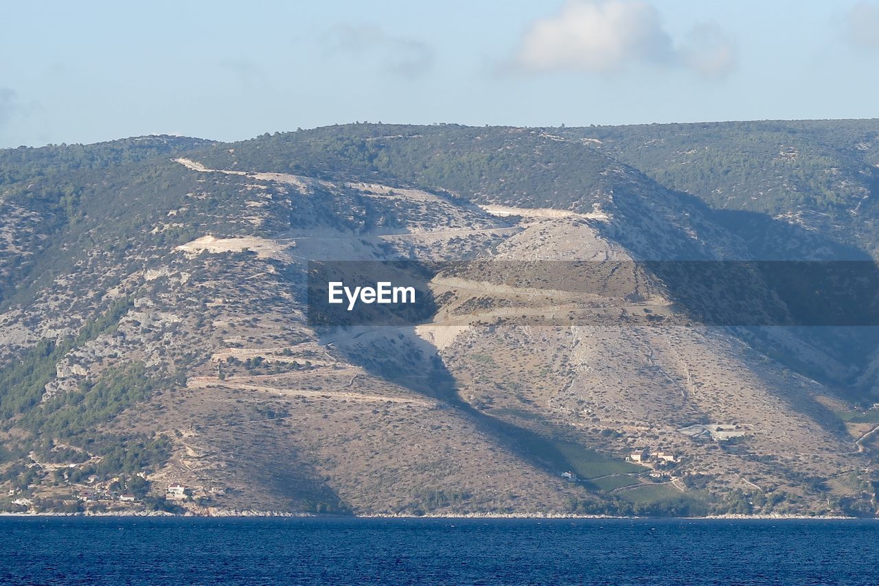 AERIAL VIEW OF SEA AND MOUNTAIN AGAINST SKY