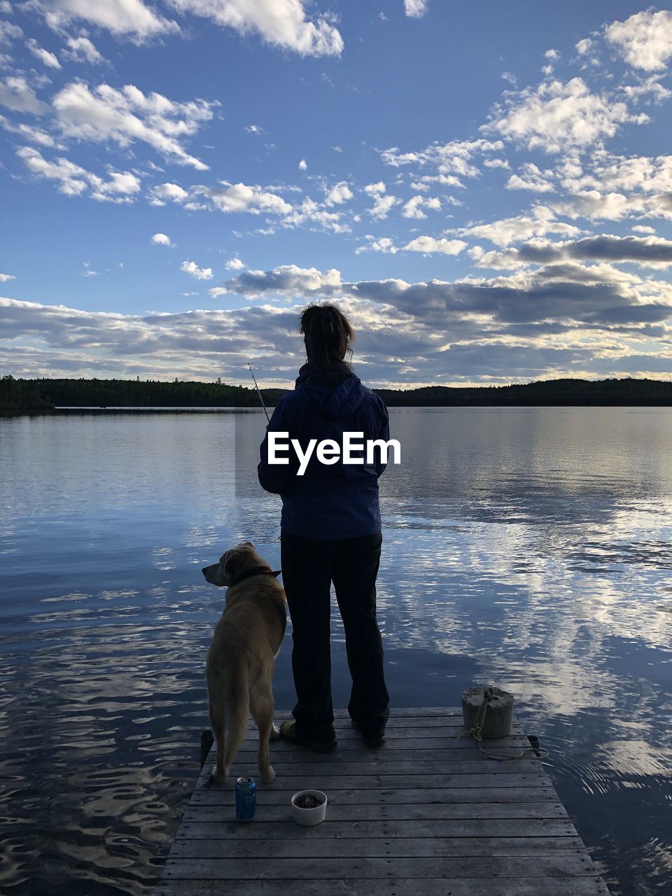 REAR VIEW OF A DOG STANDING ON LAKE