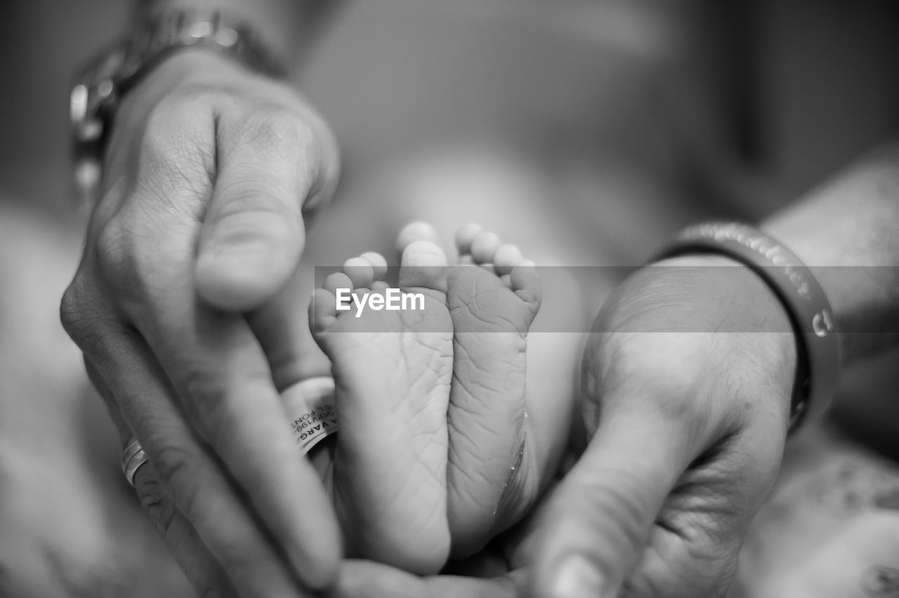 Close-up of father gesturing by baby foot