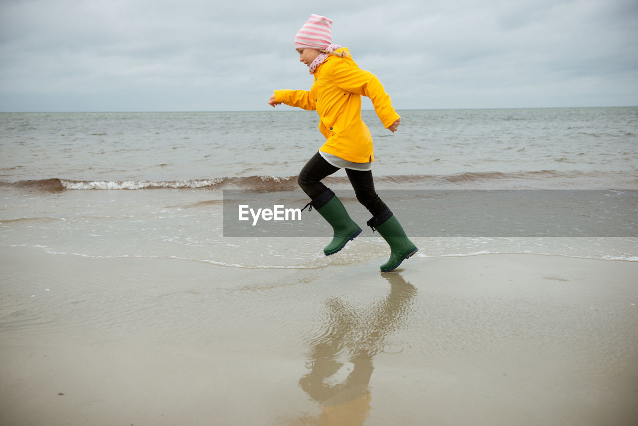 Full length of girl running at beach