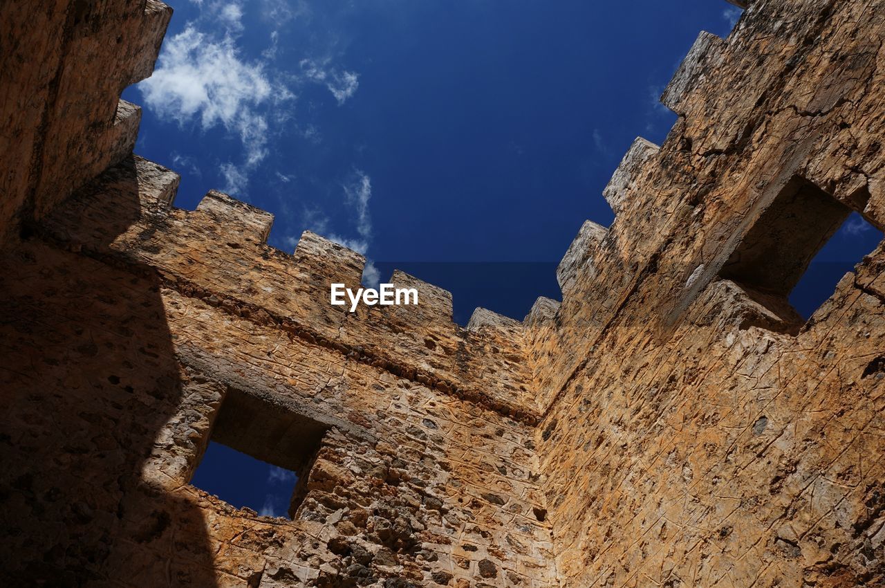 Low angle view of tower walls and blue sky