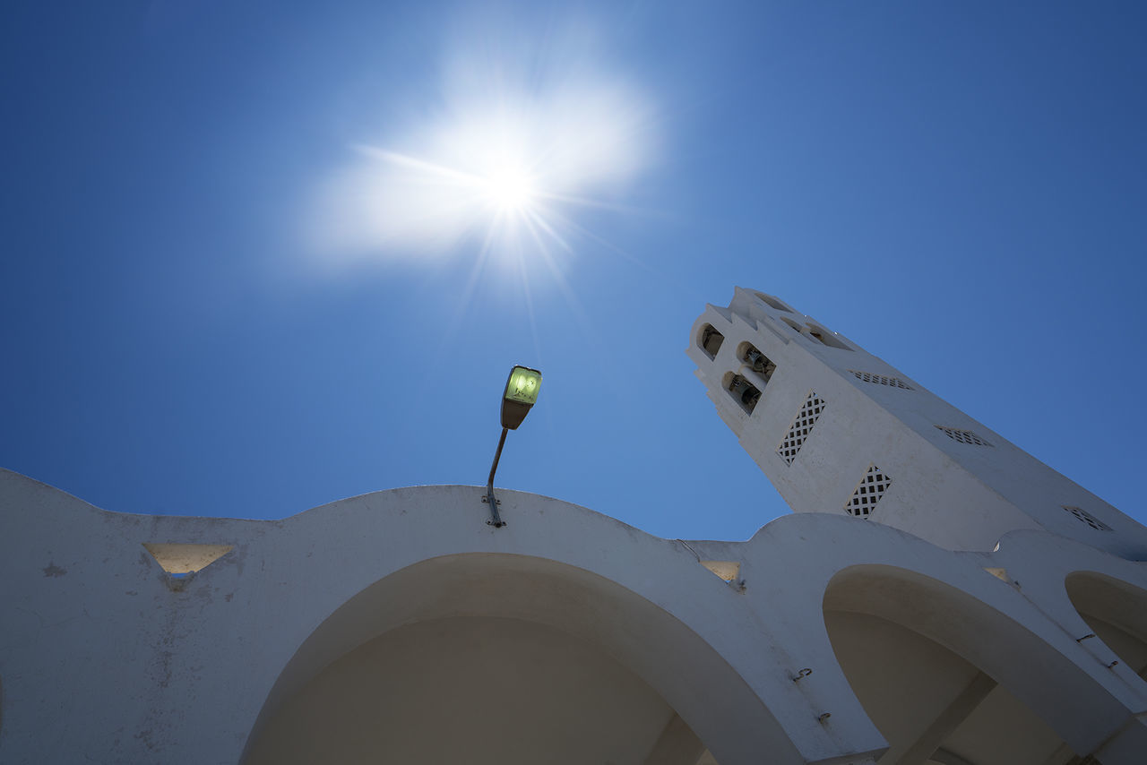 Low angle view of sun shining above church