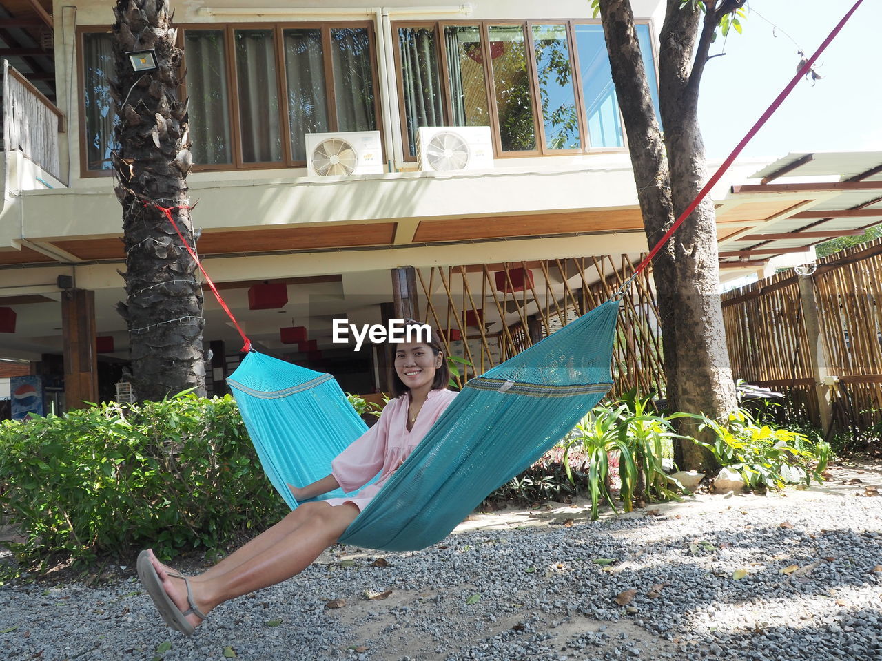 PORTRAIT OF A MAN SITTING ON HAMMOCK