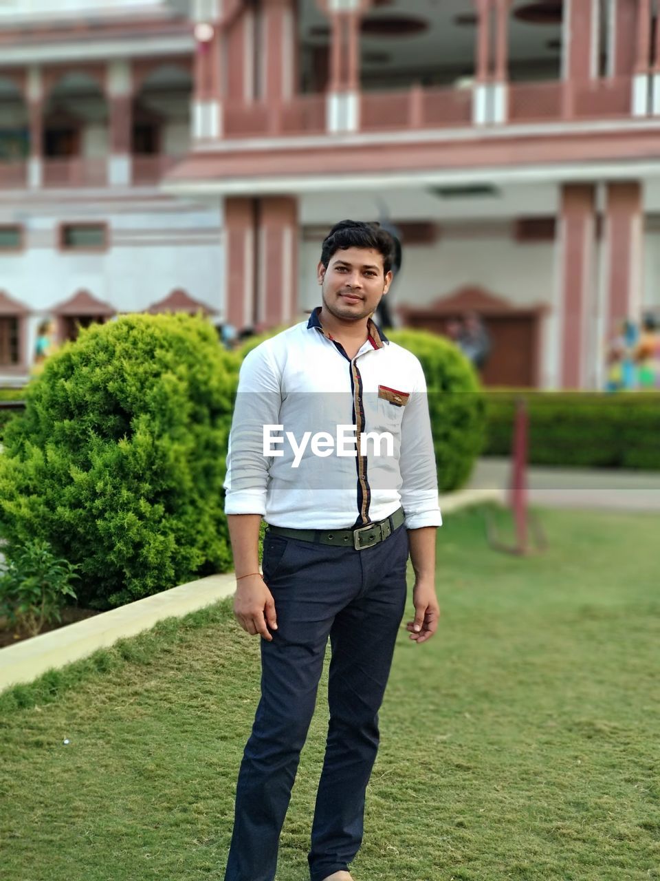 Portrait of smiling young man standing against building